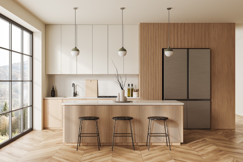 Cocina interior de casa beige con bar, nevera y estanterías con utensilios de cocina.